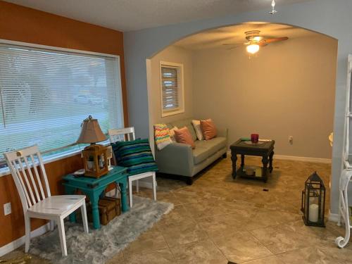 a living room with a couch and a table at Quaint Coastal Pool Home on Florida's Space Coast in Melbourne