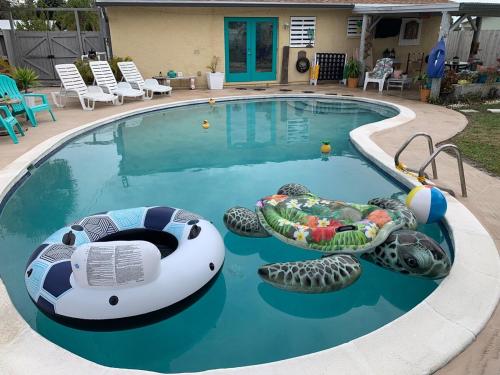 a swimming pool with inflatablelatable boats in it at Quaint Coastal Pool Home on Florida's Space Coast in Melbourne