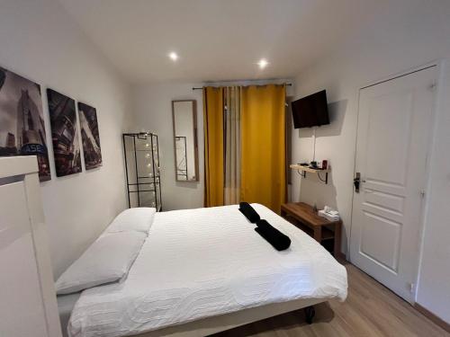 - une chambre avec un lit blanc et une porte jaune dans l'établissement T2 Modern and Cosy in St Étienne, à Saint-Étienne