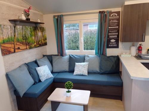 un salon avec un canapé bleu dans une cuisine dans l'établissement Evasion en Champagne, proche de Paris et des 2 Parcs, à Verdelot