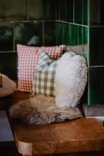 a furry seat on a table with pillows on it at Luxuriöse Schwarzwald Loft Heustock mit Sauna und Whirlpool am Griesbachhof in Titisee-Neustadt
