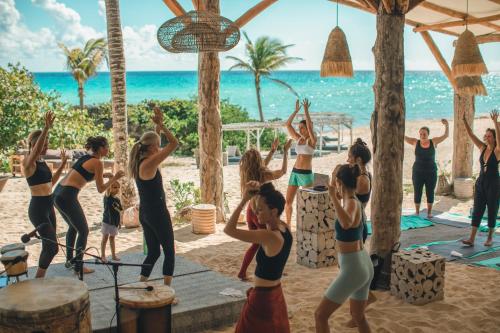 a group of people doing yoga on the beach at Palmaïa The House of AïA All Inclusive Wellness Resort in Playa del Carmen