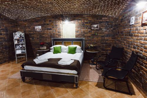 a bedroom with a bed and a brick wall at Apartament 7 Chernivtsi in Chernivtsi