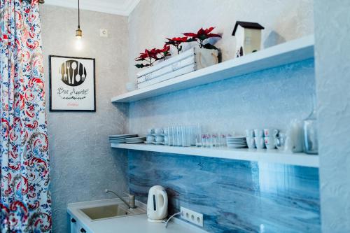 a bathroom with a sink and a shelf with dishes at Apartament 7 Chernivtsi in Chernivtsi