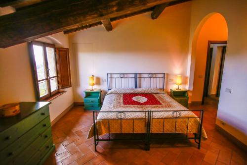 een slaapkamer met een bed in een kamer met 2 lampen bij Fattoria Abbazia Monte Oliveto in San Gimignano