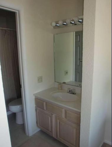 a bathroom with a sink and a toilet and a mirror at Spacious 3 BR Ozark Penthouse in Four Seasons
