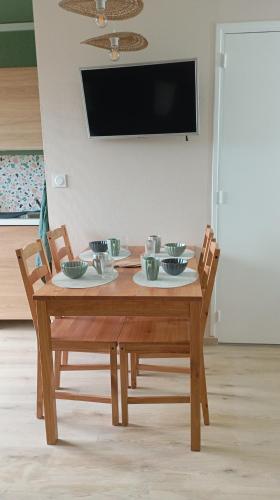 une table en bois avec quatre bols au-dessus dans l'établissement Le cocon des Rosies le Virginia Hall, à Colleville-sur-Mer