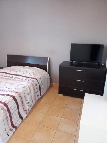 une chambre avec un lit et une télévision sur une commode dans l'établissement Chez Steph, à Saint-Germain-Nuelles