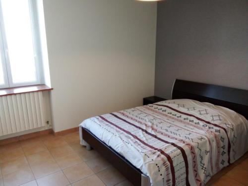 une chambre avec un lit avec une couverture dessus dans l'établissement Chez Steph, à Saint-Germain-Nuelles