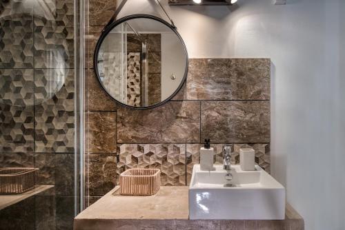 une salle de bain avec un lavabo et un miroir dans l'établissement Alicia - Appartement RDC - Parking gratuit, à Concarneau