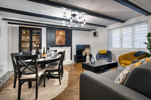 une salle à manger et un salon avec une table et des chaises dans l'établissement Alicia - Appartement RDC - Parking gratuit, à Concarneau