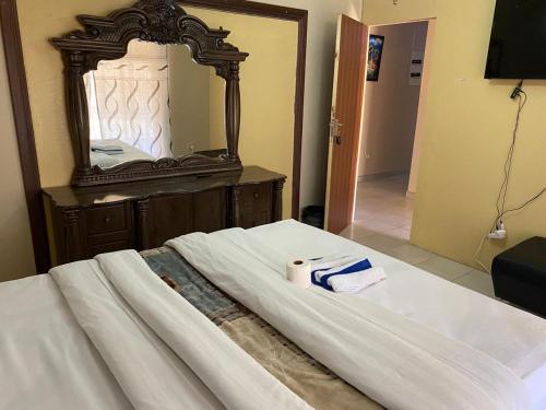 a bed with a mirror and two towels on it at Savannah Guest House Mafikeng in Mahikeng