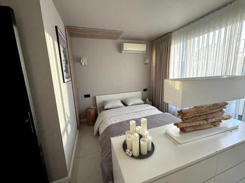 - une chambre avec un lit et une table avec des bougies dans l'établissement La maison de la plage, à Canet