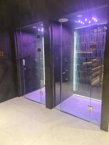 two glass doors in a room with purple lighting at Woodside Mount Kopaonik in Kopaonik
