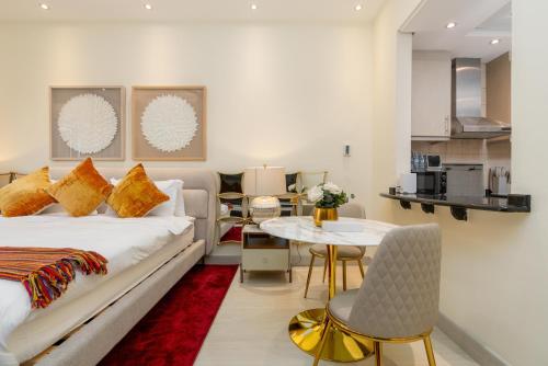a bedroom with a bed and a table and a kitchen at White Sage Incredible Studio Next to Metro in Dubai