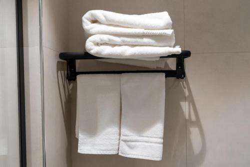 a pile of towels on a towel rack in a bathroom at White Sage Incredible Studio Next to Metro in Dubai