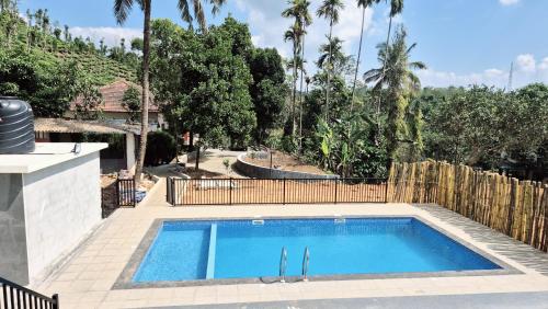 a swimming pool in the backyard of a house at Perya Hills in Periya