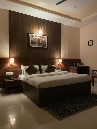 a bedroom with a large bed and two lights on at House M Lodge in Sawāi Mādhopur