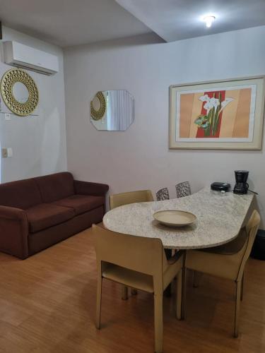 a living room with a table and chairs and a couch at Sofisticação na Savassi in Belo Horizonte