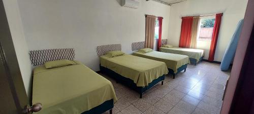a room with three beds and a window at Casa de descanso Grace in San José de Guatemala