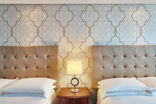 a bedroom with two beds and a tufted headboard at Hilton Porto Alegre, Brazil in Porto Alegre