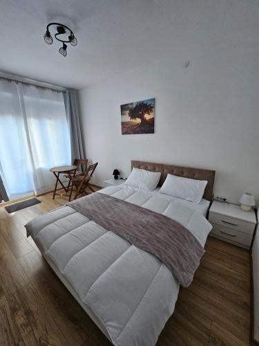 a bedroom with a large bed with white sheets at Apartman Begovic in Kolašin