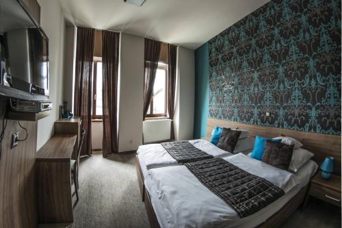 um quarto com uma cama e uma parede azul em Belvárosi Vendégház em Szekszárd