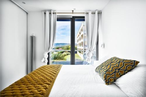 a bedroom with a bed and a large window at Private Front Beach Villa with garden and garage in Antibes
