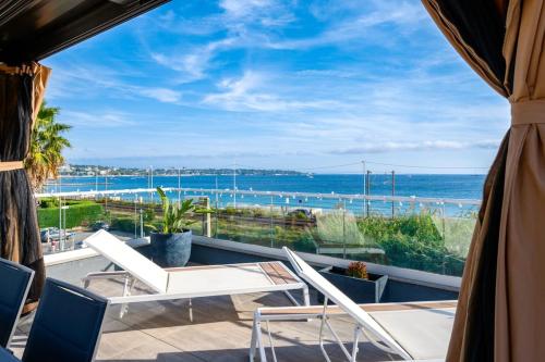 a balcony with chairs and a view of the ocean at Private Front Beach Villa with garden and garage in Antibes