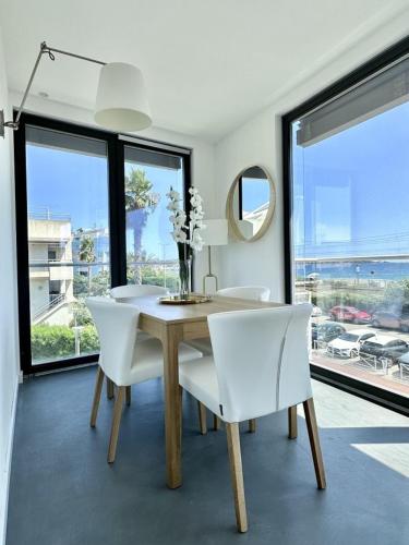 une salle à manger avec une table et des chaises blanches dans l'établissement Private Front Beach Villa with garden and garage, à Antibes