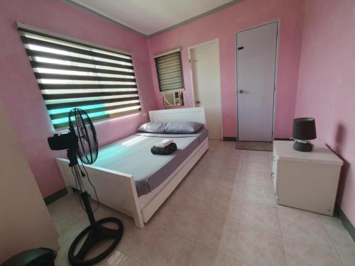 a bedroom with a bed with a window and a camera at Simala Beach House Beachfront 4BR Retreat by the Sea in Sibonga