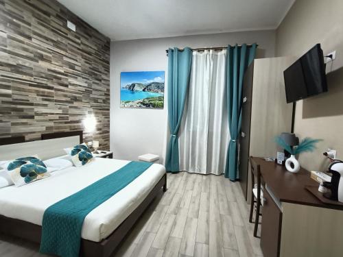 a hotel room with a bed and a television at Domos La Corte Ghibellina in Iglesias