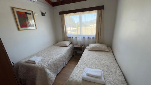 two beds in a small room with a window at Residencial del Valle in Casablanca