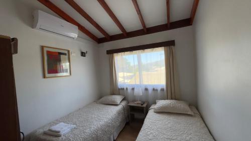two beds in a room with a window at Residencial del Valle in Casablanca