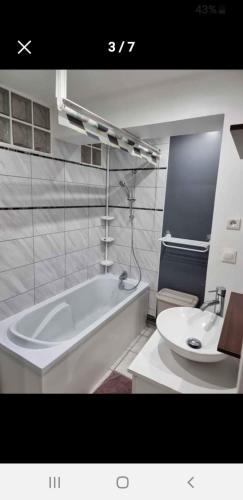 une salle de bain avec une baignoire blanche et un lavabo dans l'établissement CityCarvin, à Carvin