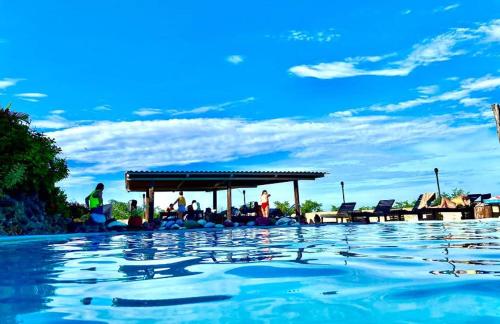 a swimming pool with people sitting under a pavilion at Vista Condor Lodge in Puerto Viejo
