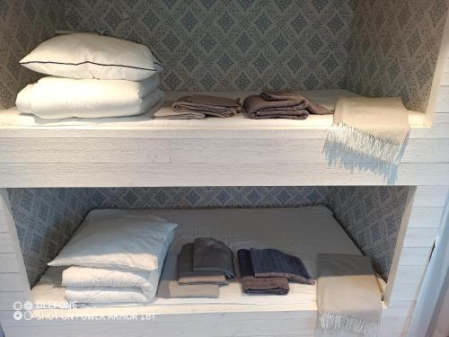 a shelf with towels and pillows in a closet at Ekereds Gårdsstuga in Dalstorp