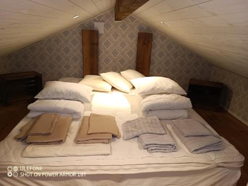 a bed with white pillows and towels on it at Ekereds Gårdsstuga in Dalstorp