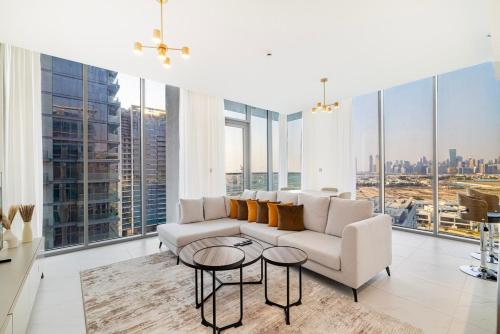 a living room with a couch and tables and windows at Luxury 2BR Prime Location & Burj Views in Dubai