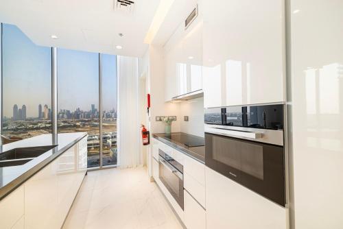 a white kitchen with a view of the city at Luxury 2BR Prime Location & Burj Views in Dubai