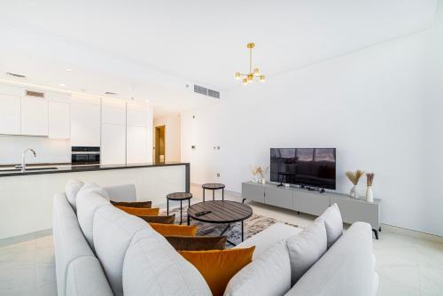 a living room with a couch and a tv at Luxury 2BR Prime Location & Burj Views in Dubai
