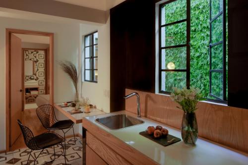 a kitchen with a sink and two chairs and a window at Casa Decu in Mexico City