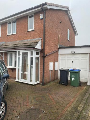 a brick house with a garage and a driveway at La ap in Wednesbury