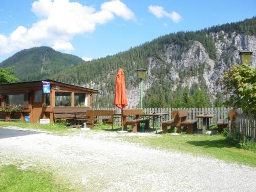 a building with a table and an umbrella in front of it at Alpengasthof Draxler in Forstau