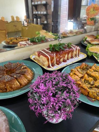 a table topped with plates of food and pastries at Pousada Granada in Rio das Ostras
