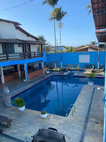 a large swimming pool with a blue wall at Pousada Granada in Rio das Ostras