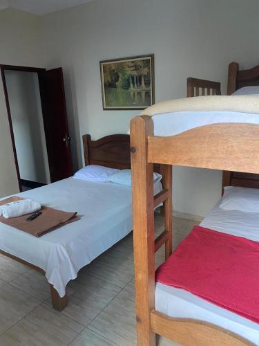 a bedroom with two bunk beds and a mirror at Pousada Granada in Rio das Ostras