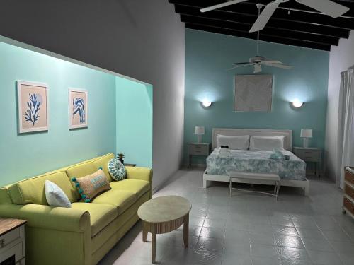 Una sala de estar con un sofá amarillo y una cama. en BidaBreezes Villa Great Location, en Palm-Eagle Beach