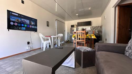 a living room with a couch and a table and a tv at Casitas Atlántida in Atlántida