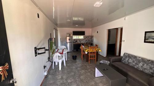 a living room with a couch and a table and a kitchen at Casitas Atlántida in Atlántida